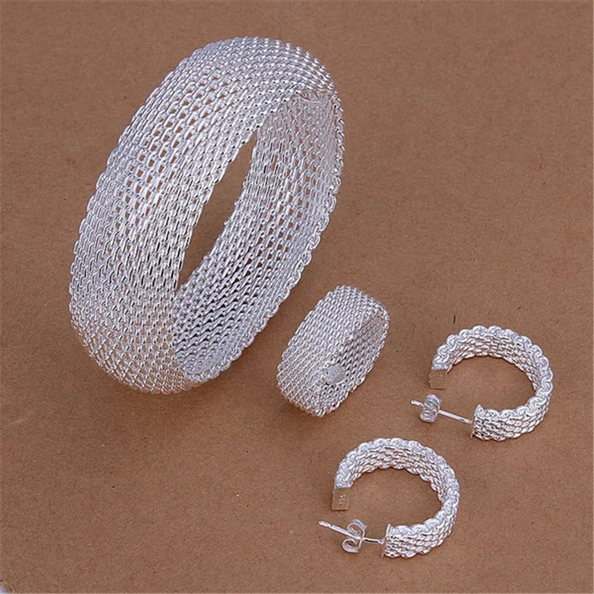Retro copper net bracelet earring ring three-piece set on a flat surface