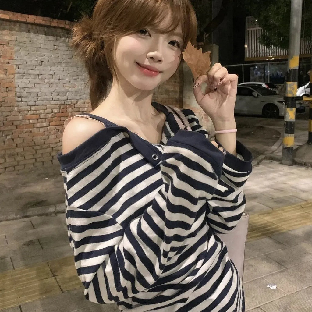 Dark blue women's long-sleeved t-shirt with an oversized fit, showing stripe and embroidery detail on the front.