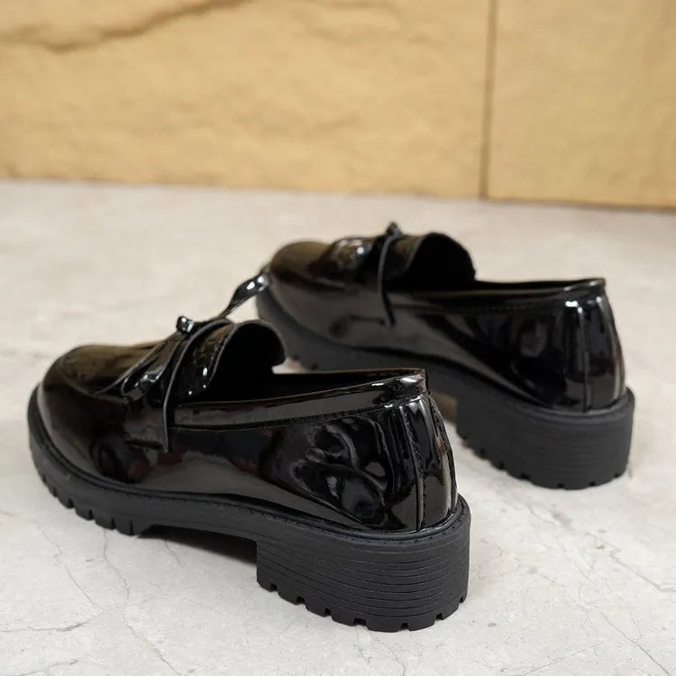 Women's black loafers with a decorative bow on the front.