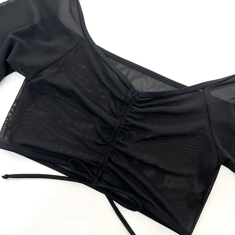 Black mesh four-piece bikini set for women with long sleeves and briefs, laid flat.
