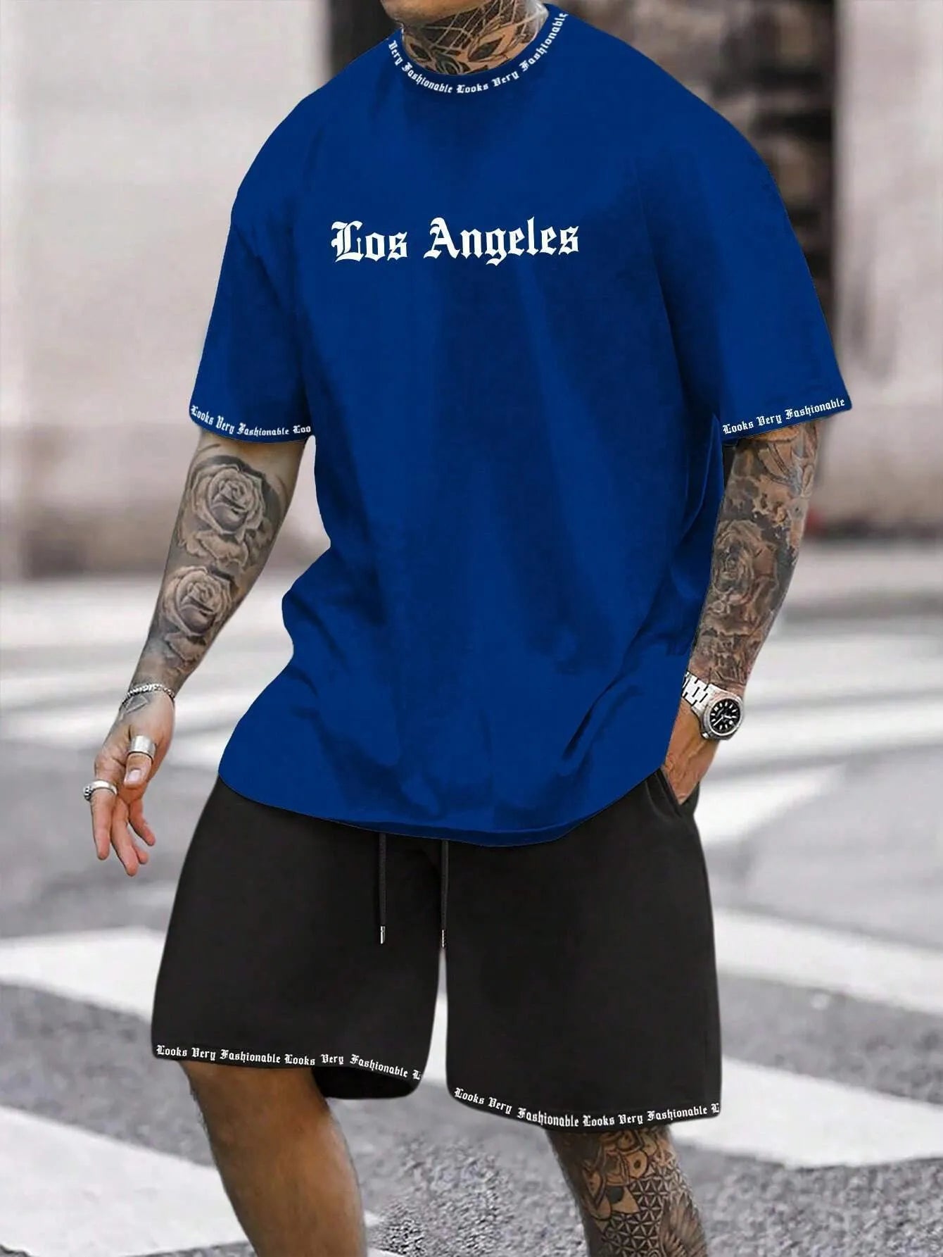 Men's blue printed short-sleeve top and matching shorts sports suit on a hanger.