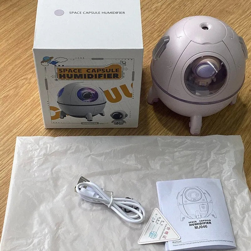 Purple portable desktop humidifier with USB cable and colourful LED light on wooden desk