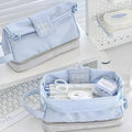 Folding double layer student pencil case in blue, navy blue, and cream white colours made from polyester fabric.