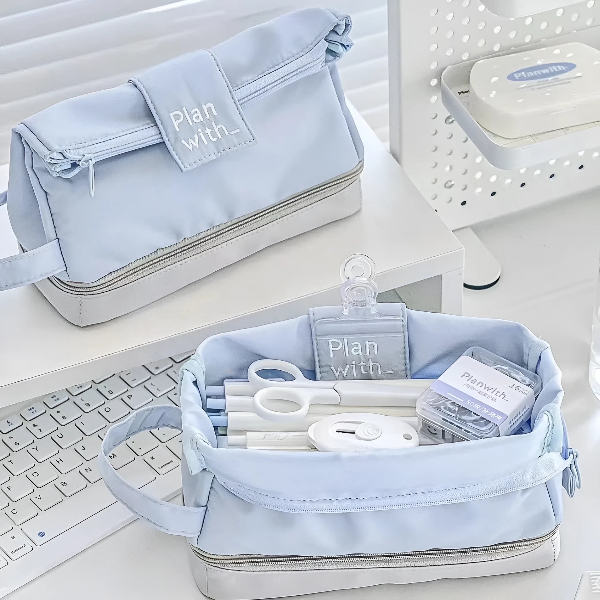 Folding double layer student pencil case in blue, navy blue, and cream white colours made from polyester fabric.