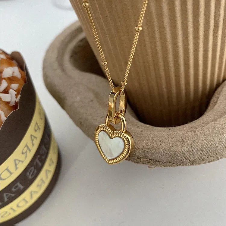 Double-sided shell love pendant necklace with mixed gem inlay on adjustable chain, available in gold-plated copper or titanium steel