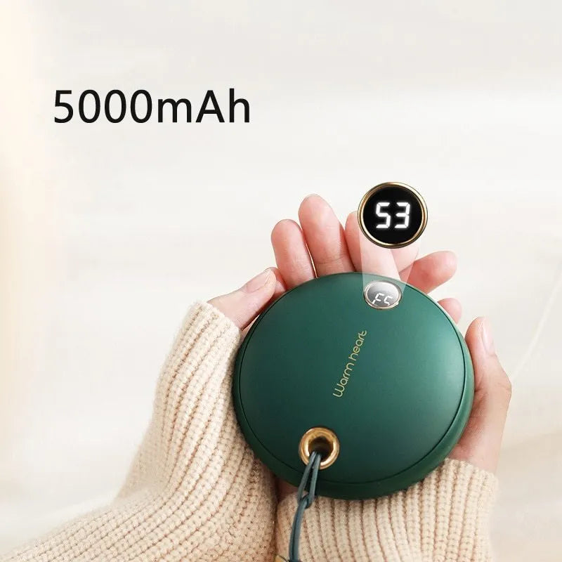 Green hand warmer power bank with digital display showing battery percentage, next to a charging cable.