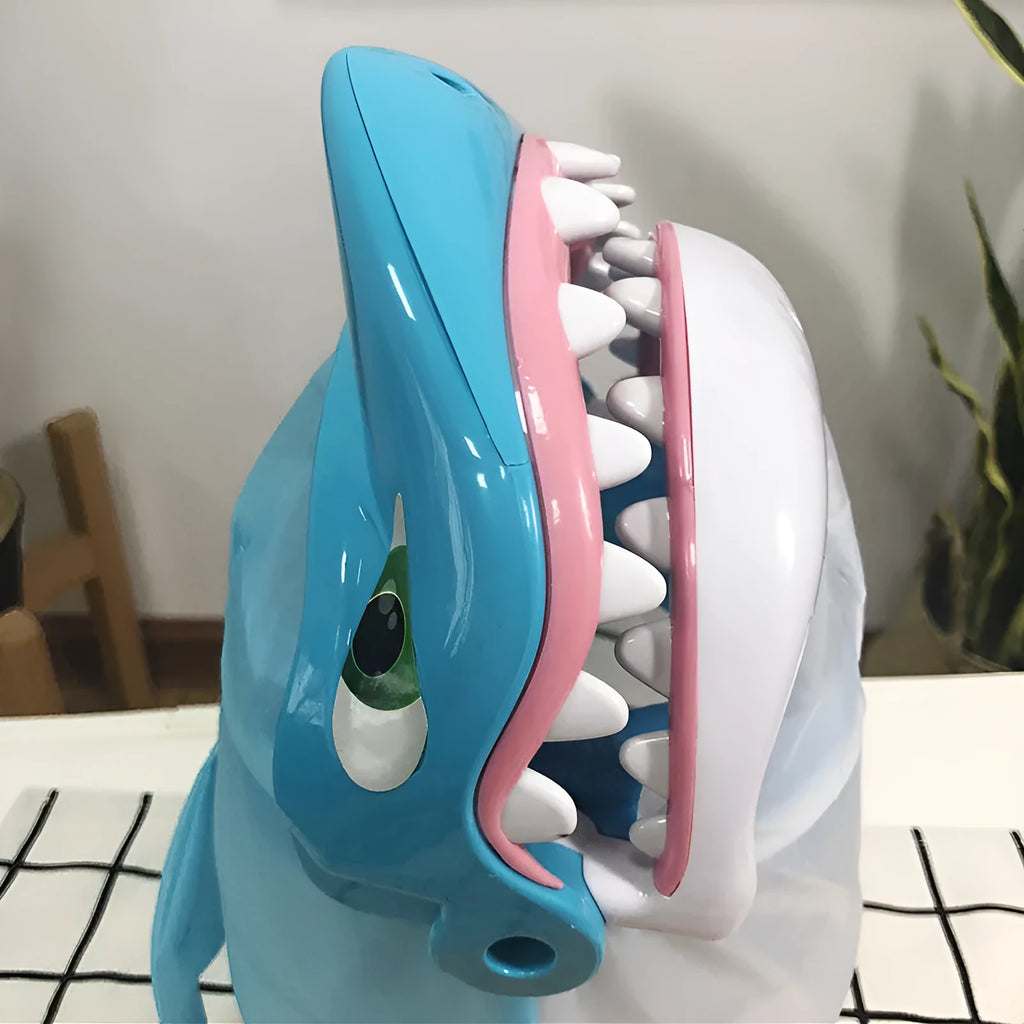 Great white shark tricky toy with small plastic fish inserted in its mouth on a tabletop