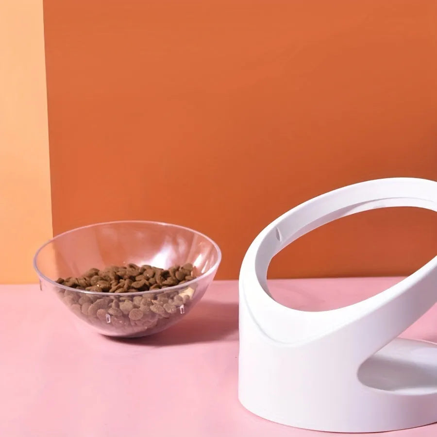White elevated tilted plastic cat food bowl on a flat surface