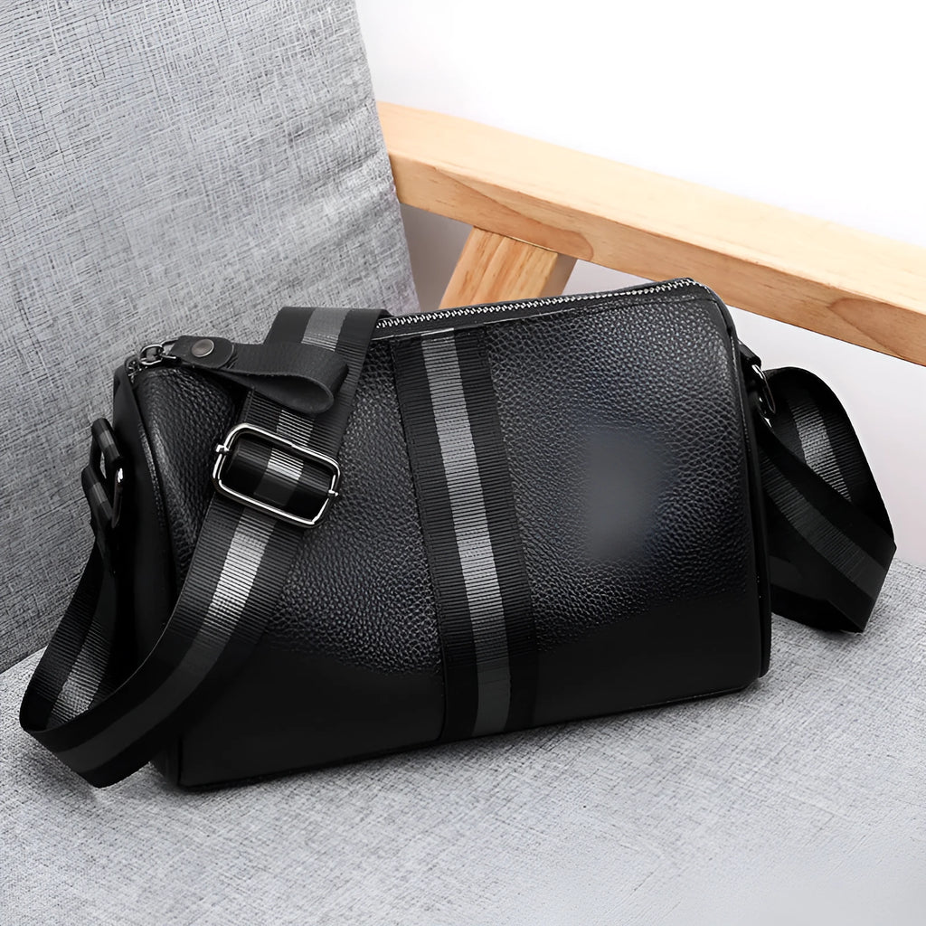 Black genuine leather crossbody bag showing single shoulder strap and structured 24x16x13cm design.