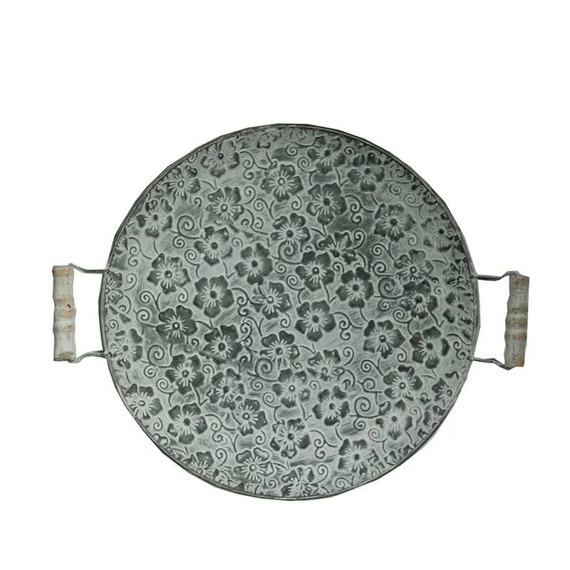 Round wrought iron storage tray in two sizes on a wooden table.