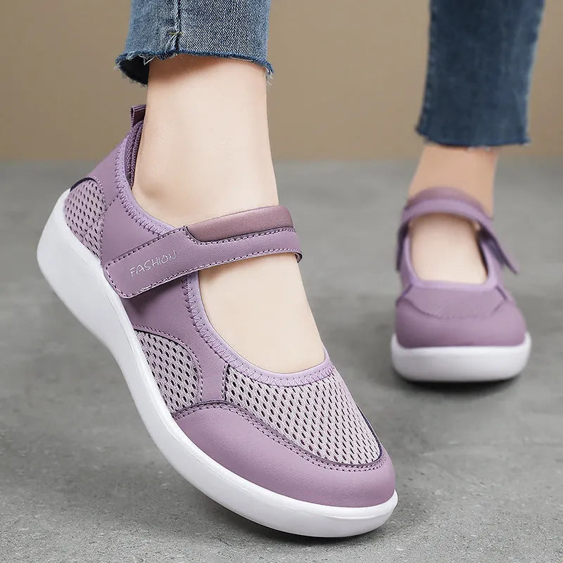 Women's grey breathable mesh slip-on shoe with Velcro strap, flat heel, and round toe.