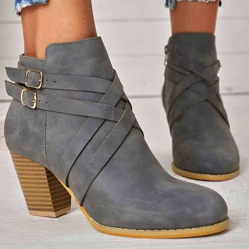 Women's short ankle boot with 7cm heel, side zipper, and belt buckle detail in grey.