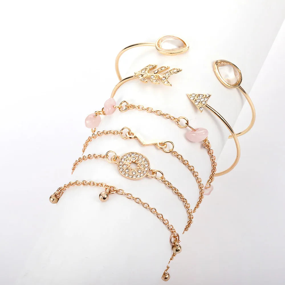 Gold-coloured zinc alloy bracelet set with arrow and V-shaped water droplet design elements