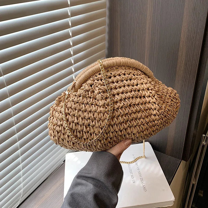 Women's woven straw shoulder bag with shell shape in khaki colour featuring chain detail