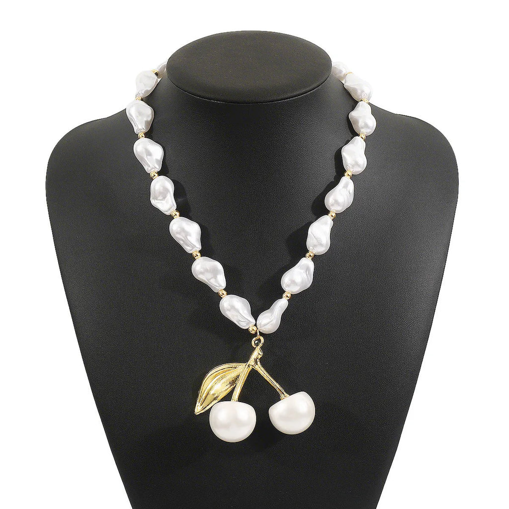 Gold coloured alloy cherry fruit pendant on an adjustable imitation pearl necklace for women.
