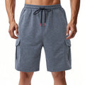 Man's heavy terry fabric cargo shorts in light grey, showing loose fit and multiple pockets.