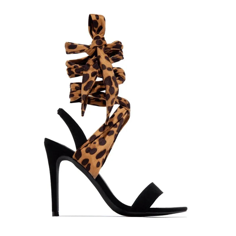 Light brown leopard print women's high heel sandals with Roman style cross straps and a thin high heel.