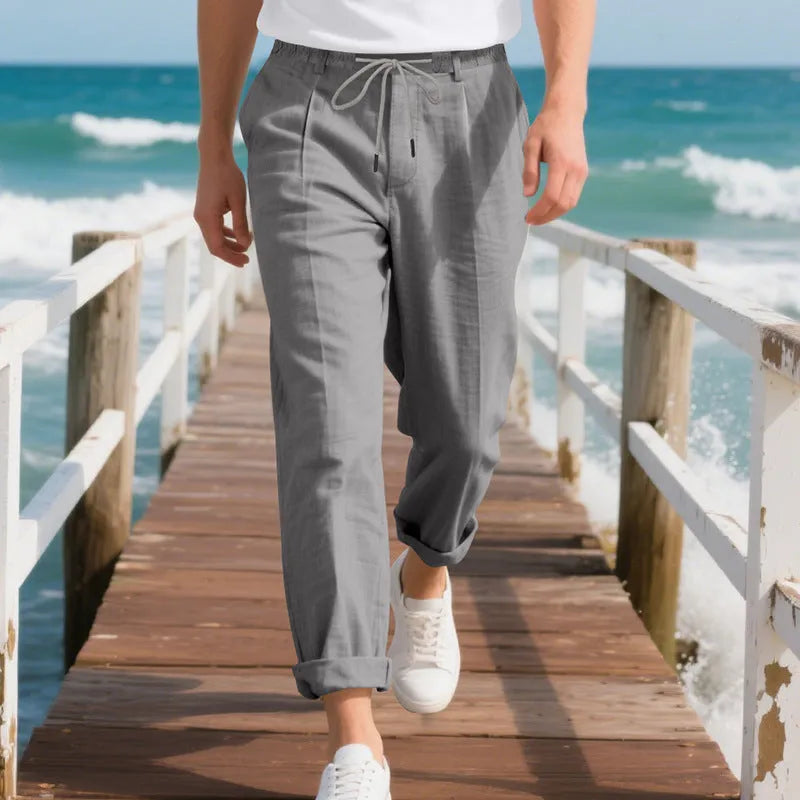 Men's light khaki linen casual trousers with a drawstring waistband and straight-leg silhouette.