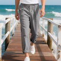Men's light khaki linen casual trousers with a drawstring waistband and straight-leg silhouette.