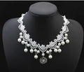Three-piece white pearl jewellery set with necklace, earrings, and bracelet on display
