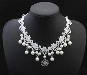 Three-piece white pearl jewellery set with necklace, earrings, and bracelet on display