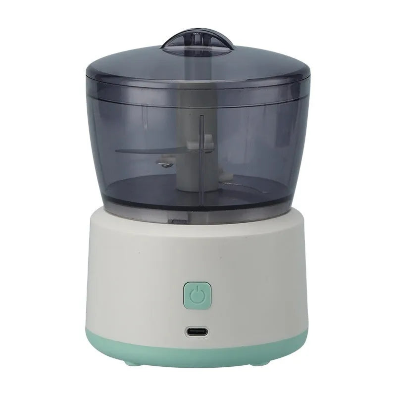 Mini electric meat grinder with transparent processing cup and stainless steel blades in white or light green