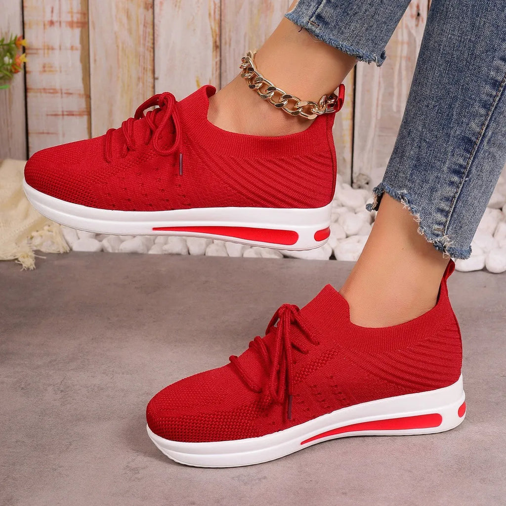 Women's low-top black fly-knit sneakers with round toe and white lace-up front.