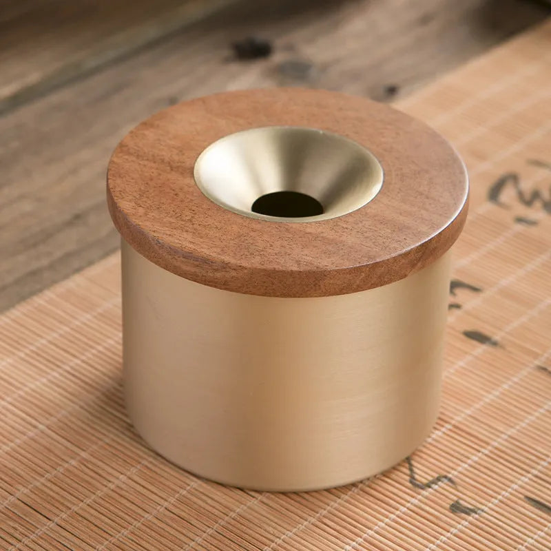 Brass ashtray with wooden lid in blackwood or rosewood finish, 6 cm diameter, on a table.