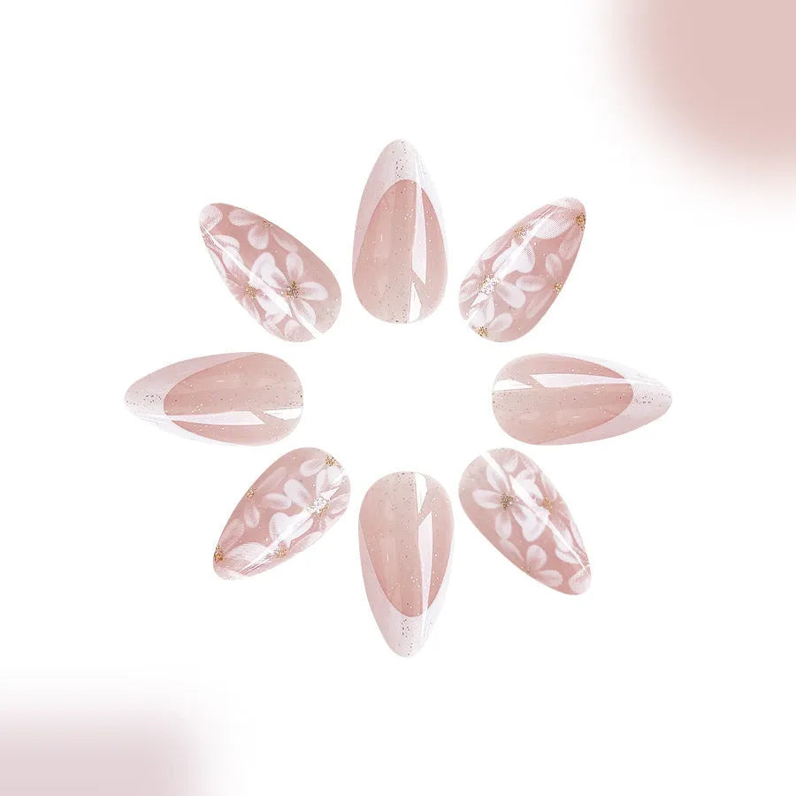 Short glossy almond-shaped press-on nails with French style, floral designs and glitter accents in C625 colour