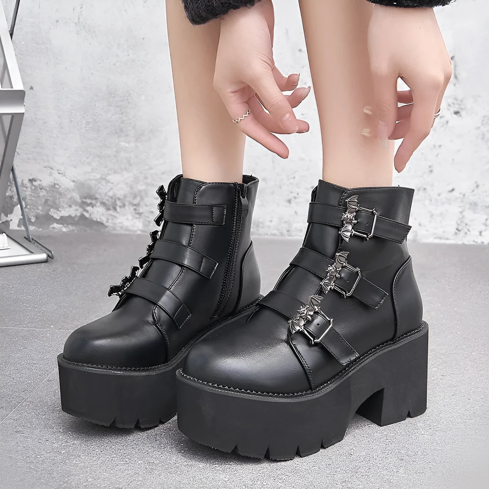 Black women's punk boots with bat buckle, side zip, thick heel, and round toe.