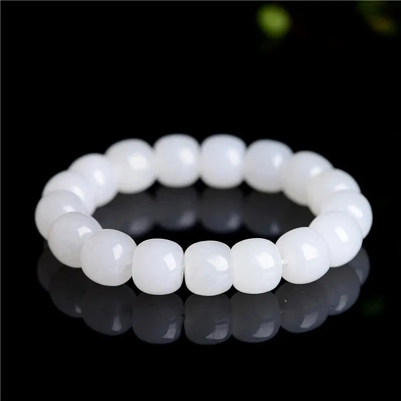 White jade barrel bead bracelet on wrist showing traditional Hetian jade material and barrel-shaped bead design