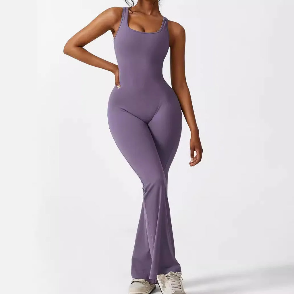 Woman wearing a sleeveless army green flare jumpsuit for yoga.