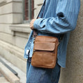 Men's brown genuine leather crossbody shoulder bag with sewing line detail.