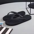 A pair of rubber flip-flops with a fish label on the strap, showcasing a non-slip patterned sole.