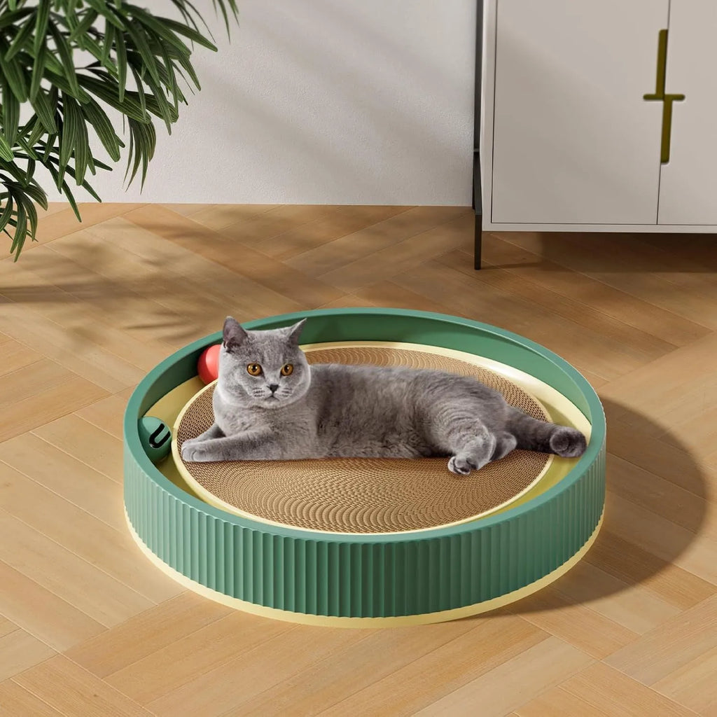 Large green cardboard cat scratching board with three coloured ball toys attached on a flat surface.