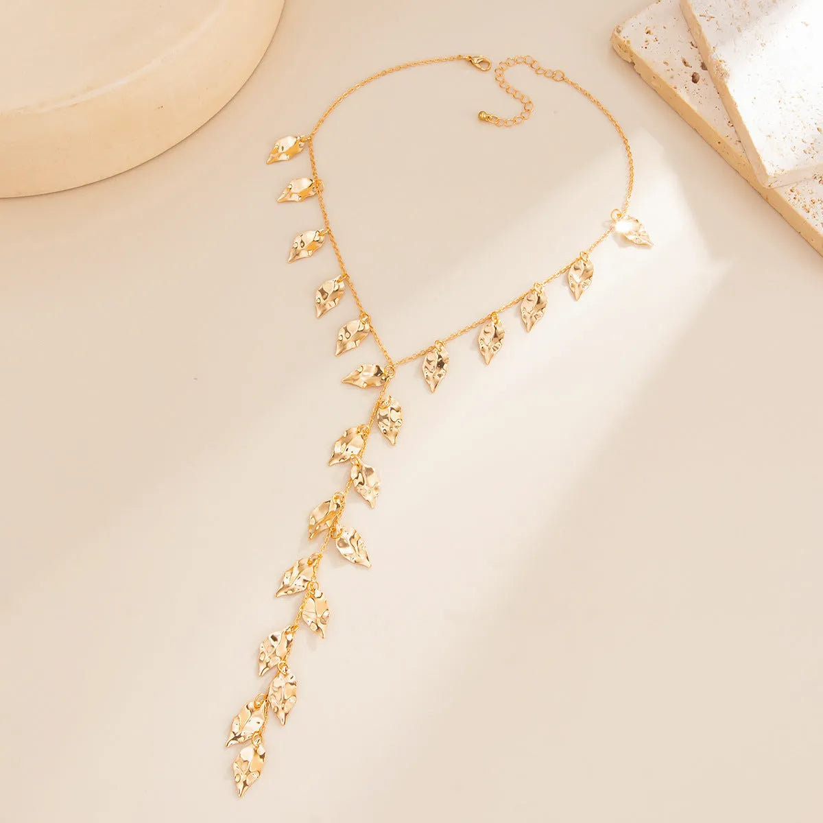 Y-shaped leaf fringe pendant necklace gold tone on white background, copper chain, iron leaf pendant