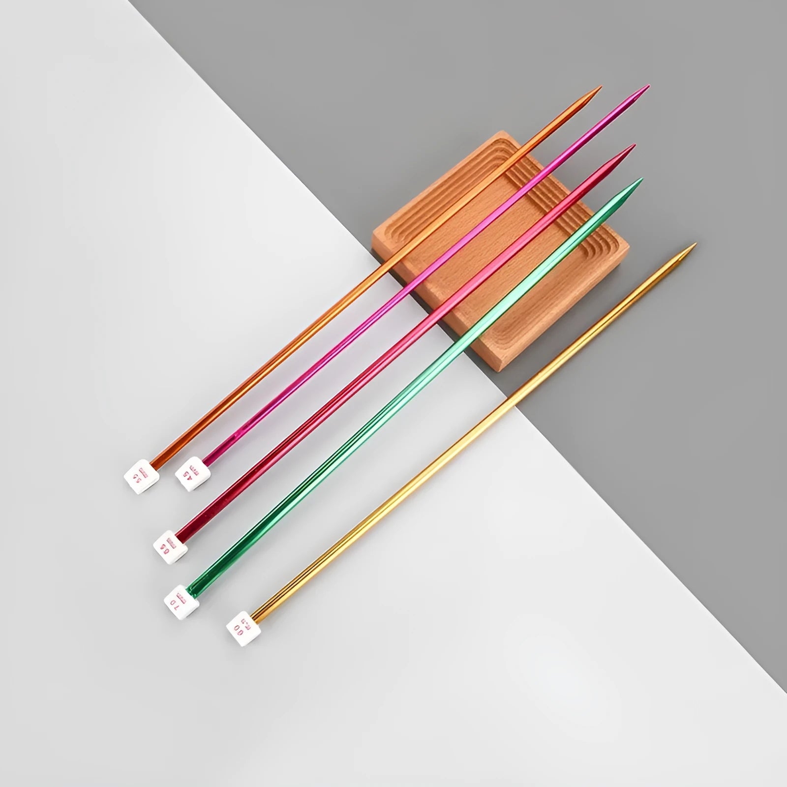 Set of long-handle metal crochet hooks with protective end caps arranged by size