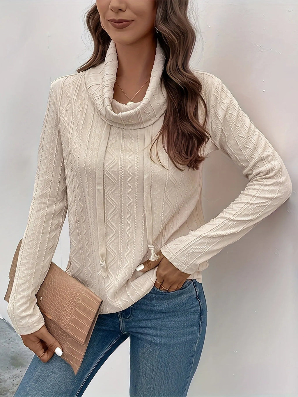 Apricot coloured women's hooded pullover sweater with long sleeves on a hanger.