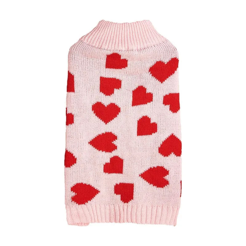 Small dog wearing an acrylic sweater with pink bow and love heart design