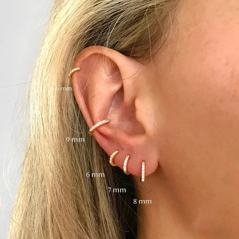Gold, rose gold, and silver circle stud earrings with a perforated geometric design on a white background.