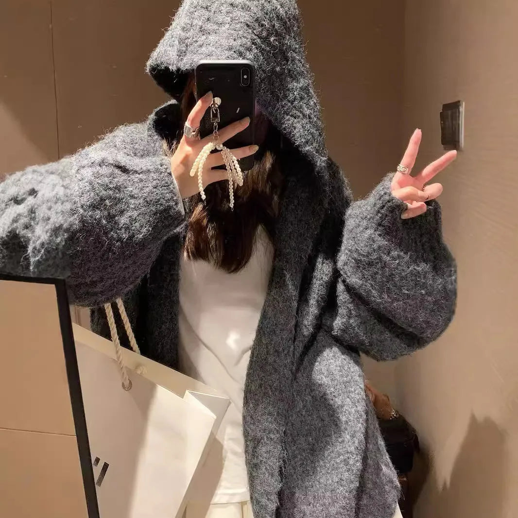 Woman wearing a brown retro-style Maillard hooded cardigan with a thick knit and loose fit.