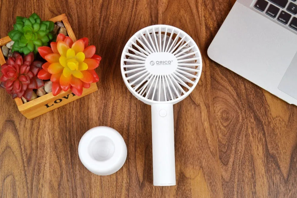 White ORICO FH1 USB rechargeable portable fan with fine-line texture on desk.