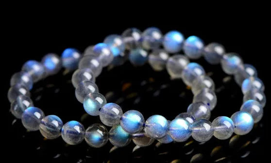 Natural blue moonlight cream body crystal bracelet on wrist, showing single strand of polished beads.