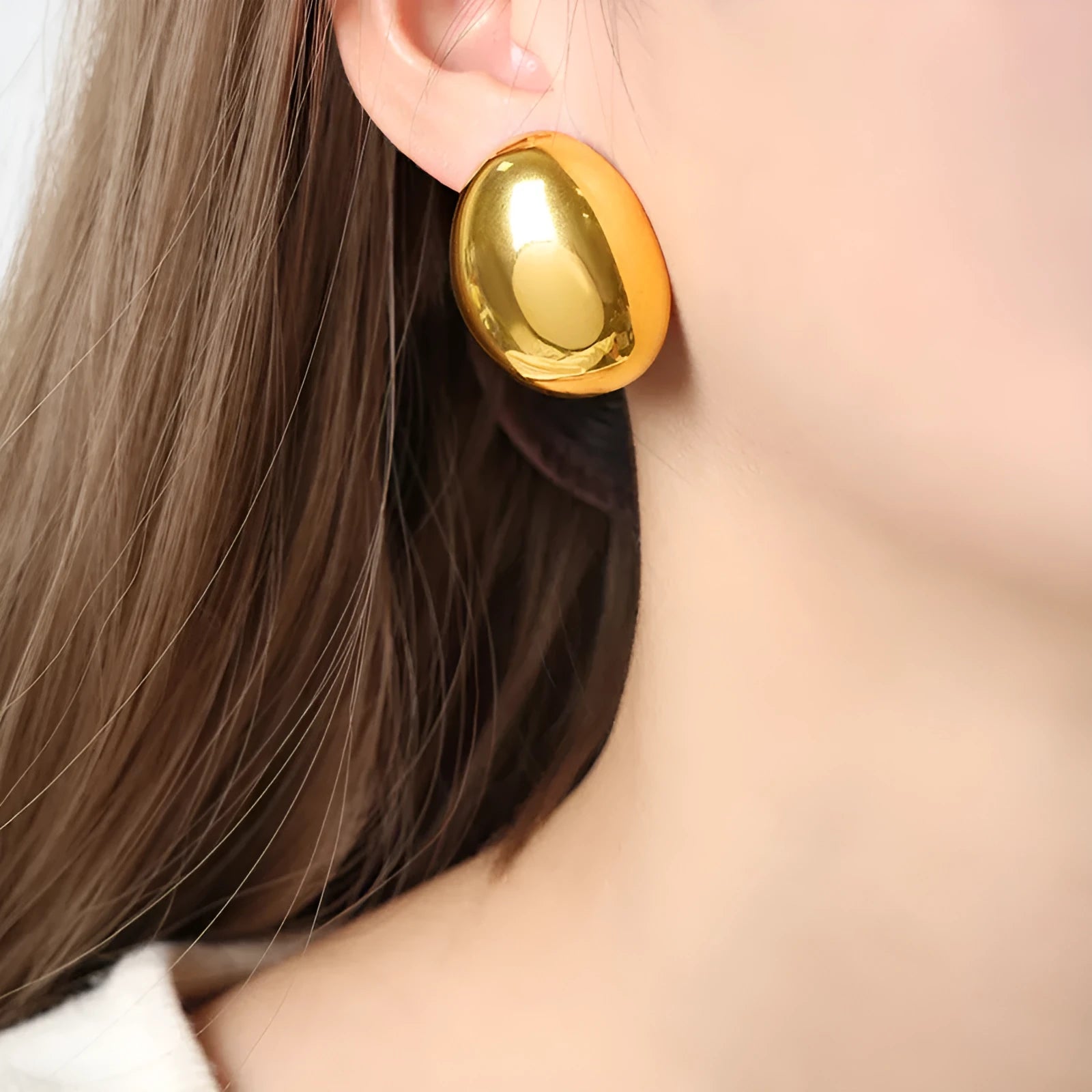A pair of geometric line design ear studs with a high-shine glazed silver finish.