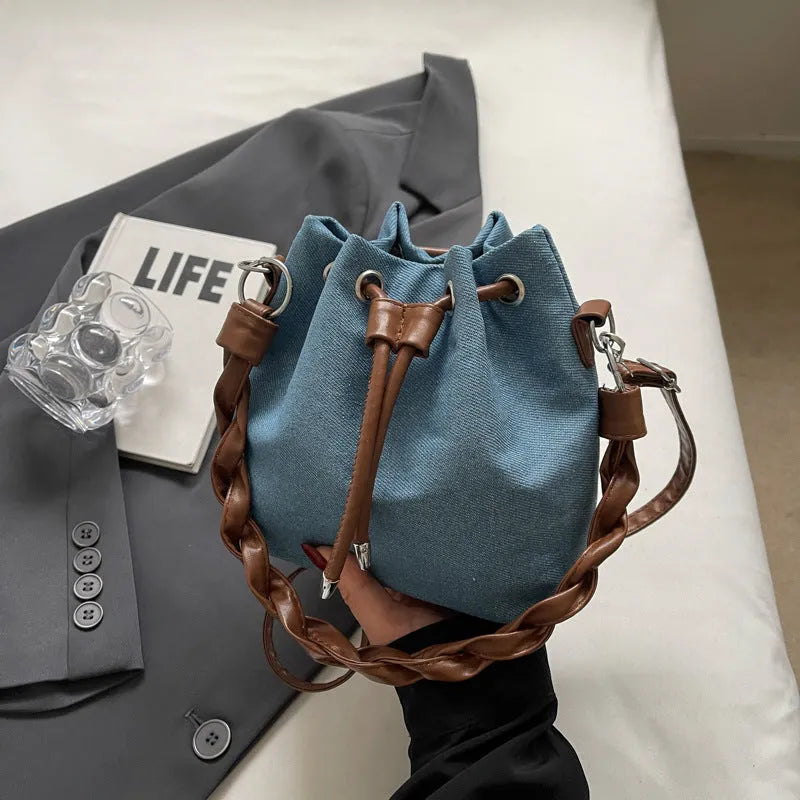 Blue cross body bucket bag with synthetic leather lining and hanging drop ornaments