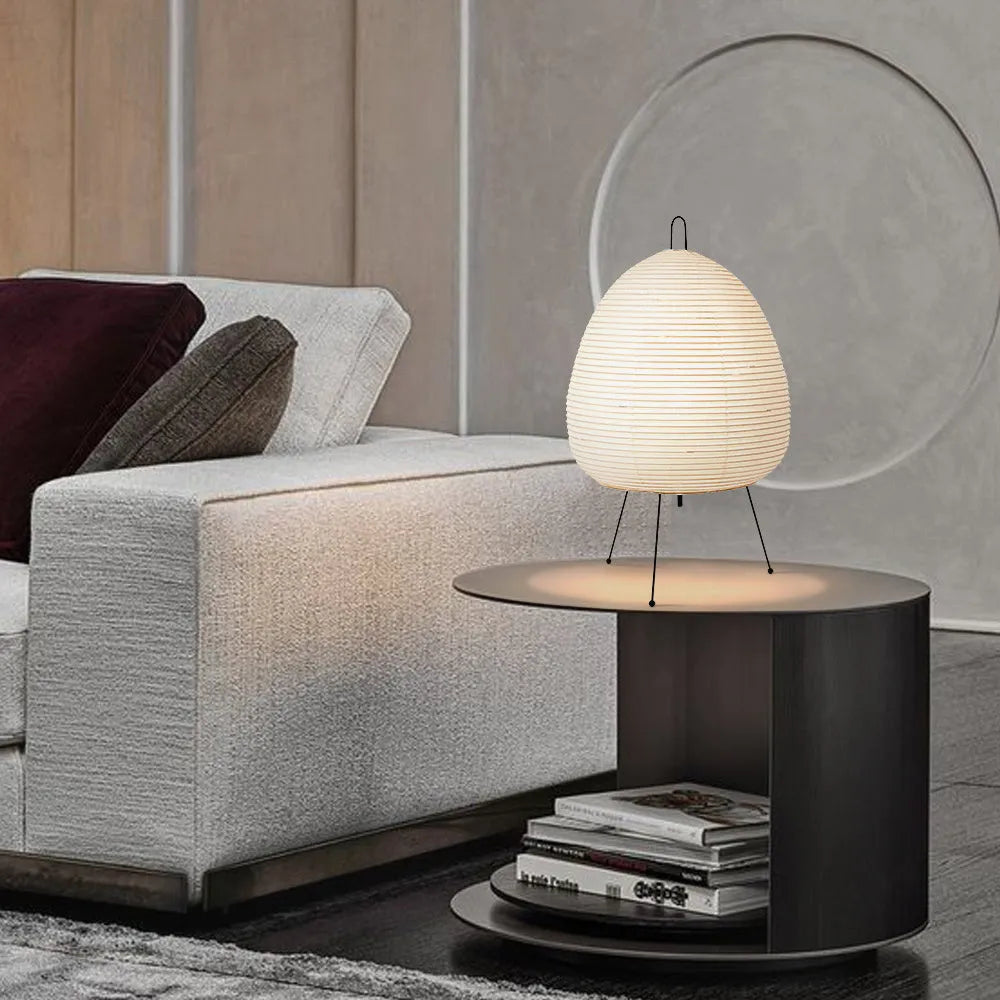 Japanese style table lamp with handmade paper shade and aluminium base on a wooden surface.