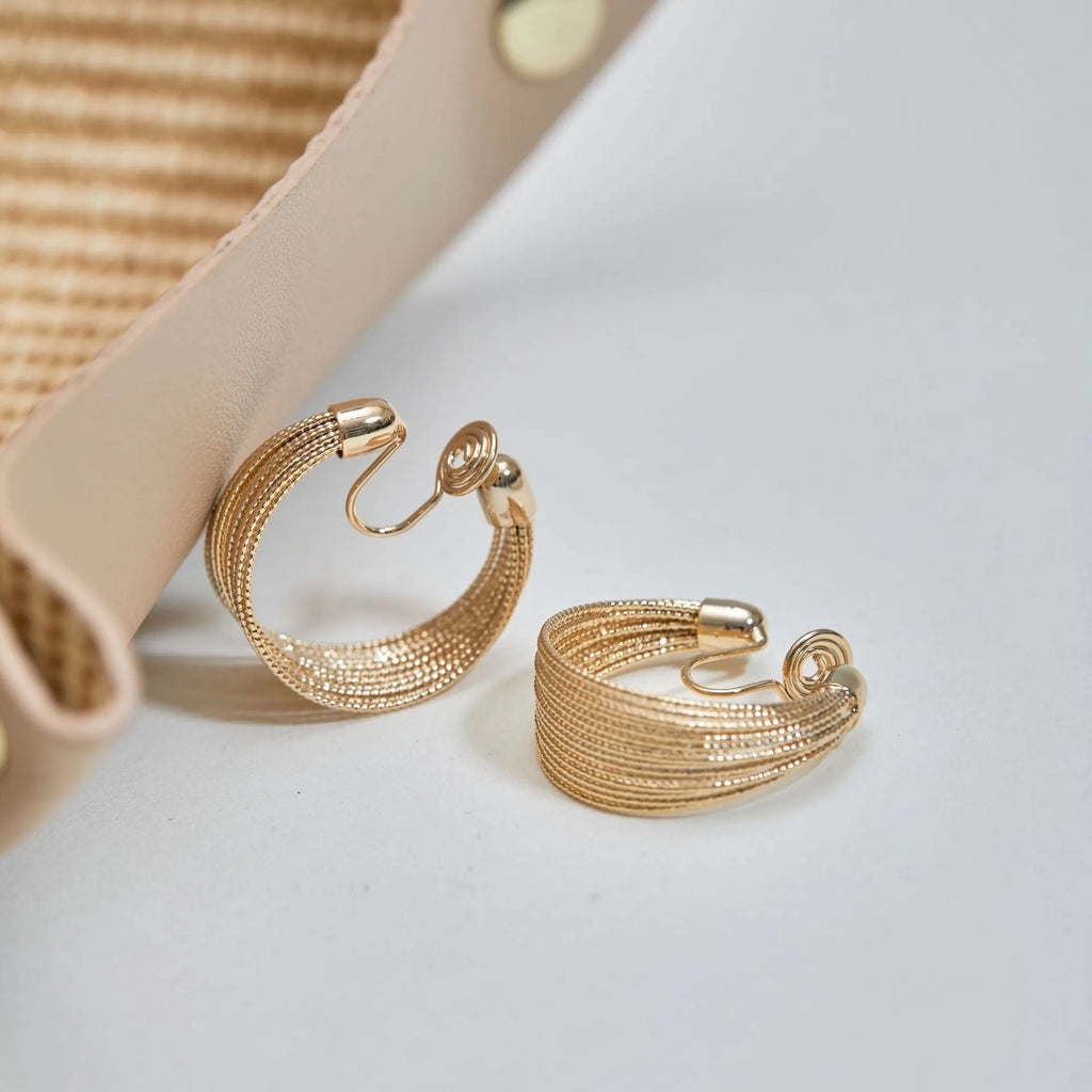 Set of geometric multi-layer earrings in gold and silver, showing stud and clip styles on a flat surface.