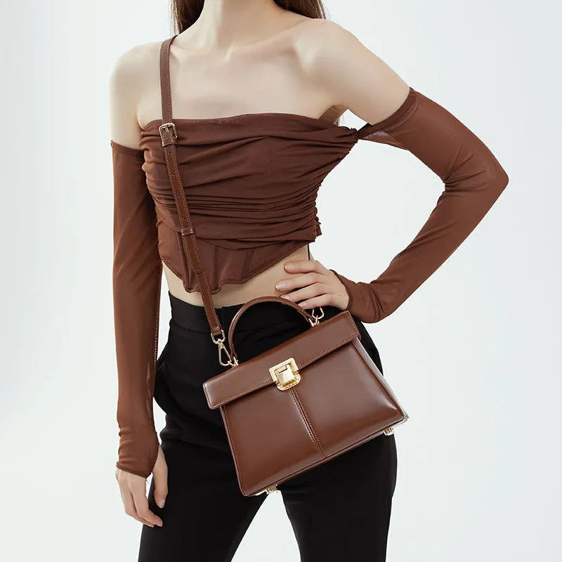 Women's black leather shoulder bag with vachette clasp showing organised interior compartments