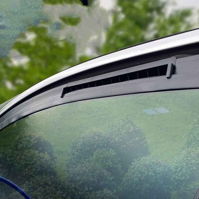 Black and white USB-powered car ventilation fan for exhaust odour removal on a car dashboard.