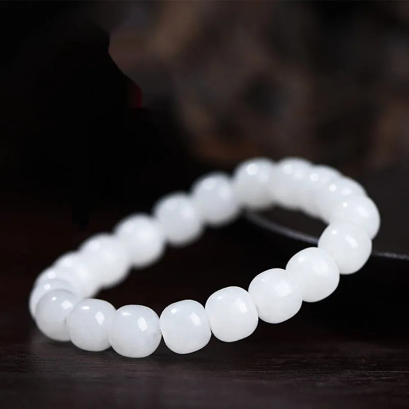 White jade barrel bead bracelet on wrist showing traditional Hetian jade material and barrel-shaped bead design